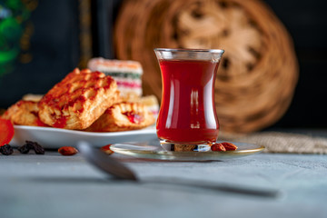 Turkish tea in an authentic glass with sweets, dried fruits and nuts for a teatime