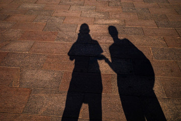 Shadows of two people on paving slabs