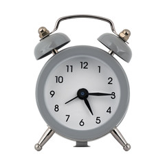 A gray clock with an alarm clock on a white background shows the arrows five hours fifteen minutes or seventeen hours fifteen minutes