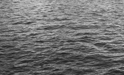 Water surface black and white abstract background. Natural aqua wallpaper with empty seacoast of colorless waters 