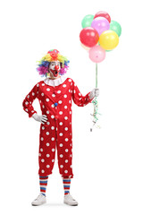 Cheerful clown holding a bunch of balloons