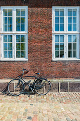 Fototapeta na wymiar Exterior architecture. Vintage bicycles in front of brick facace in Copenhagen, Denmark