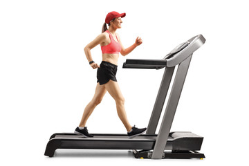 Smiling young female exercising on a treadmill