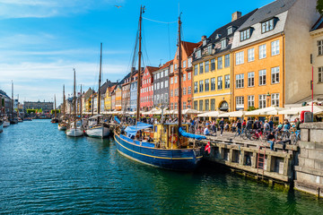Fototapeta premium View of Nyhavn pier with color buildings, ships, yachts and other boats in the Old Town of Copenhagen, Denmark