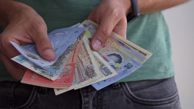 A man shows banknotes of different countries.