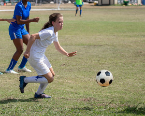 Young athletic teen girl playing in a soccer game