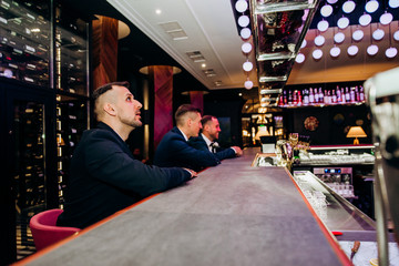 The groom and him friends are sitting at the bar