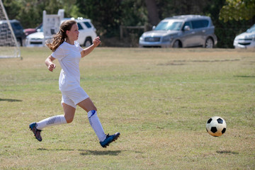 Young athletic teen girl playing in a soccer game