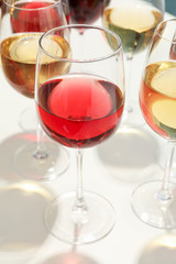 Glasses with different wine on white background, closeup