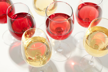 Glasses with different wine on white background, closeup