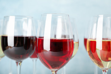 Glasses with wine against light blue background, blurred lights, closeup