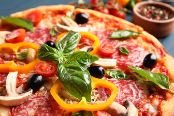Delicious pizza and ingredients on wooden background, close up