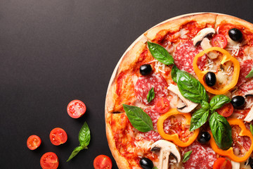 Delicious pizza and tomatoes on dark background, copy space