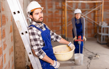 Portrait of builder in process of finishing work in cottage