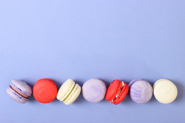 macaroons on a colored background top view.