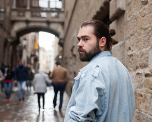 Fototapeta premium Handsome adult man with a beard in a jeans jacket