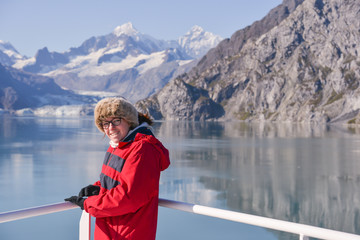 Young woman smiles at the camera with a Glacier in the background whilst on vacation.