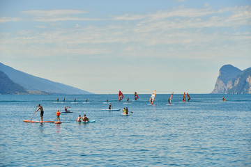 Water sports on Lake Garda in Torbole resort. Windsurfer Surfing The Wind On Waves, Recreational Water Sports, Selective focus