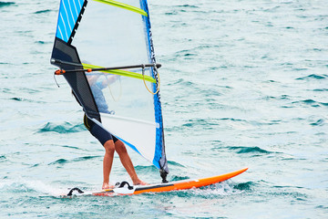 Windsurfing on Lake Garda. Unidentifiable Windsurfer Surfing The Wind On Waves, Recreational Water Sports, Selective focus