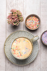 Cappuccino coffee in a mug on a saucer..Flat lay composition of coffee, flowers and sweets, top view, copy space.