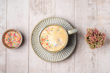 Cappuccino coffee in a mug on a saucer..Flat lay composition of coffee, flowers and sweets, top view, copy space.