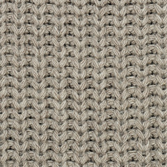 The texture of the knit fabric is beige. Abstract background. Close-up.