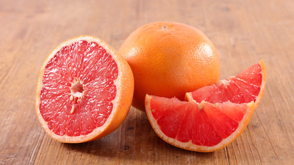 grapefruit and slices on wood background