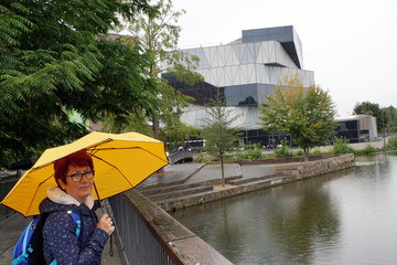 Frau mit gelbem Regenschirm Science Center Heilbronn am Neckar