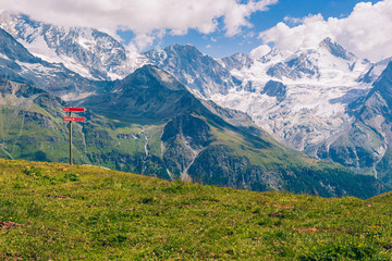 Spectacular view on high snowy peaks of the Pennine Alps under cloudy sky seen from Sorebois in the summer. Zinal, Val d' Anniviers, Valais, Switzerland
