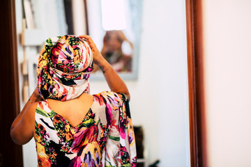 Ethnic diversity race woman at home trying coloured dress and foulard in front of a mirror