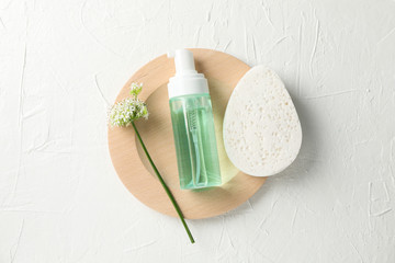 Lotion, allium flower and sponge on white background, copy space