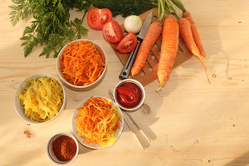Korean side dishes for a barbecue dinner - kimchi and various kinds of vegetables, a set of fermented foods useful for intestinal health - top view of glass bowls on a wooden background,