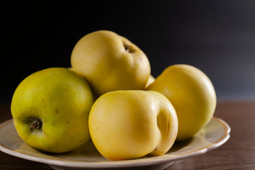 healthy eating. many green apples in a white plate on a dark background