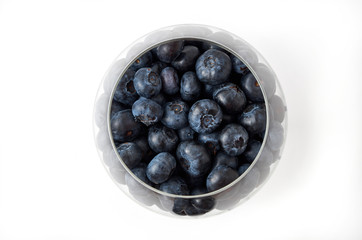 blueberries in a glass vase on a white background. glass vase on a white background. Top view