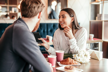 Young couple using smartphone during date