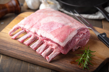 raw lamb rack on wooden cutting board
