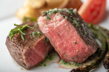 fillet mignon steak with asparagus, tomato and potato on white plate