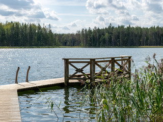 beautiful summer view of Valdis lake shore, wooden footbridge by the lake, Latvia