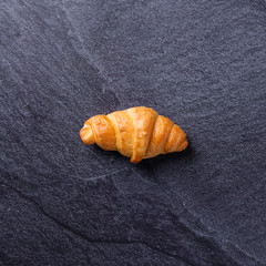 Fresh croissants on a black slate background. Top view Copy space