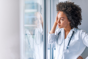 Doctors face heavy levels of stress too. She's had to make some tough decisions today. She's been under a lot of stress lately. Portrait of stressed doctor woman in office