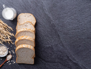 Bread slice on black slate background. Top view Copy space