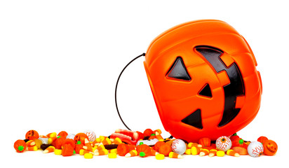 Halloween Jack o Lantern bucket with spilling candy, side view isolated on a white background © Jenifoto
