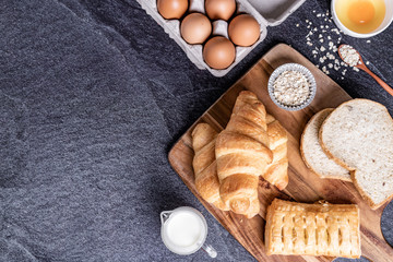 Fresh croissants and Bread slice on black slate background. Top view Copy space