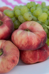 Fototapeta na wymiar Grape and peach on a plate. Fruits close up. Beautiful picnic.