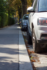 geparkte Autos am Straßenrand mit Gehsteig