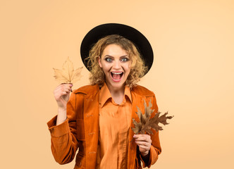 Autumn sale. Leaf fall. Fashion woman with leaves. Autumn clothing and color trends. Autumn woman in black hat. Beautiful surprised girl with autumn leaf. Fashion trends for fall. Autumnal foliage.