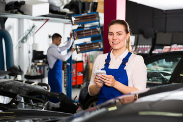 Girl mechanic taking notes on notebook