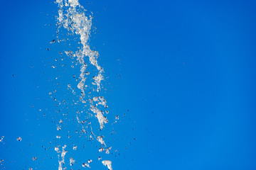 Fototapeta na wymiar Flying water drops on blue background