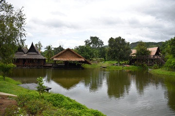 Fototapeta na wymiar Kanchanaburi, Thailand, 09.09.2019: Beautiful garden, lake, traditional Thai, Siamese clothes, buildings of 