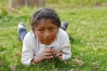 Serious native american girl laying on the grass.